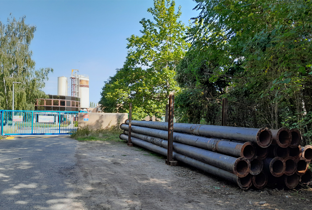 Ensemble de canalisations provisoires empilées devant l'entrée de la station d'épuration